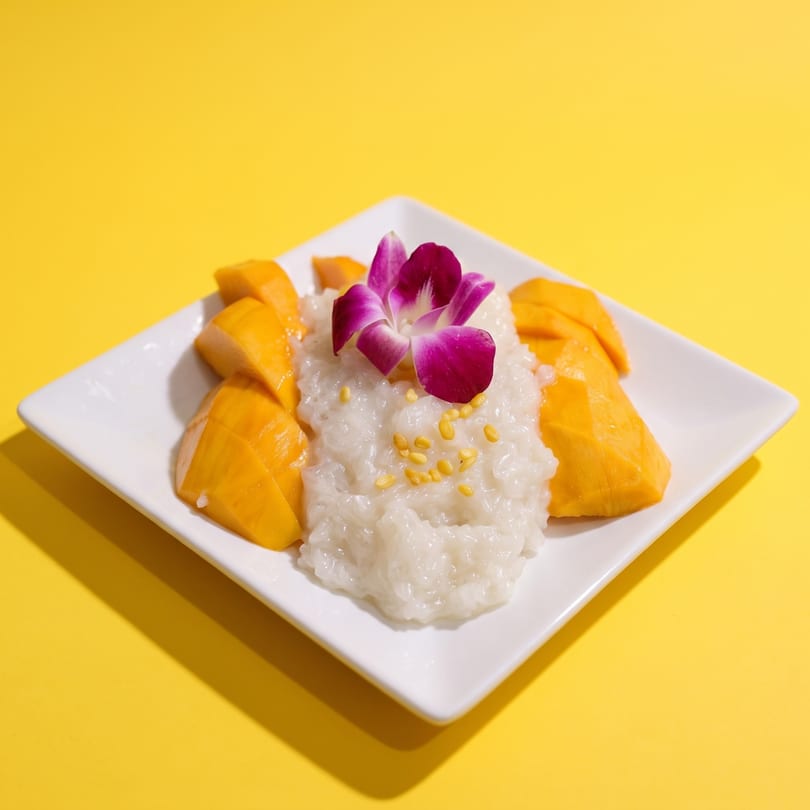 Mango sticky rice with orchid garnish